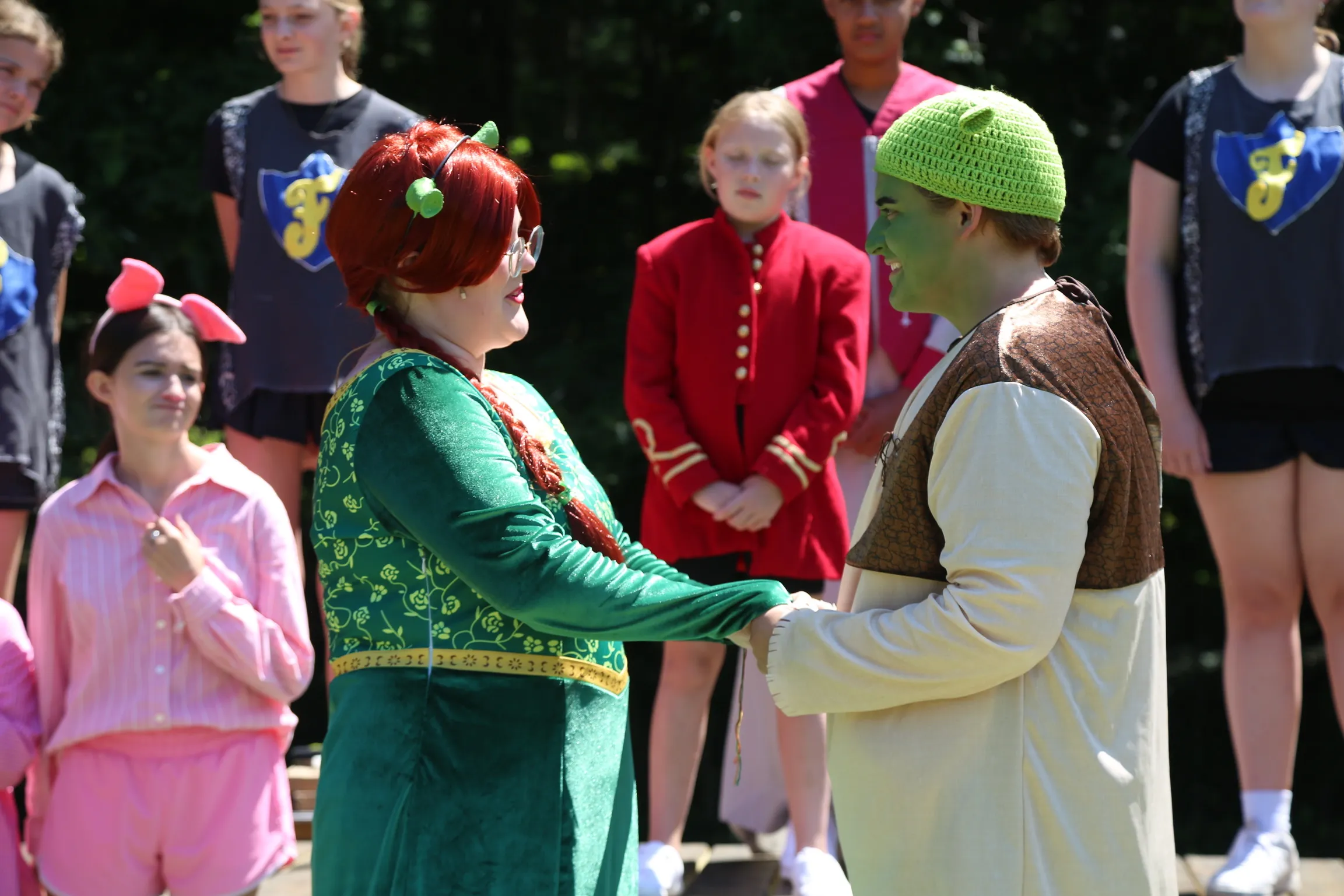Shrek and Fiona face each other on the outdoor stage during the camp production
